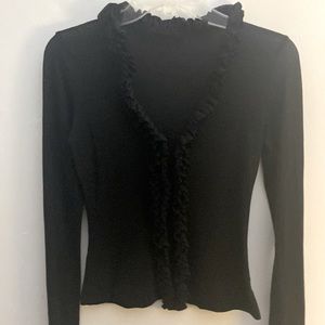 Black stretchy shirt v neck with ruffles around neck and down the middle.